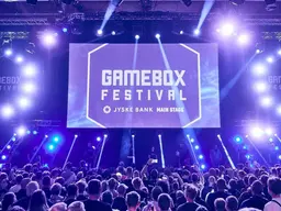 Arkivfoto af Gamebox Festivals scene med publikum og blå og lilla scenebelysning.