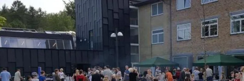 Arkivfoto af Allerød Bibliotek med mennesker på pladsen foran bygningen.