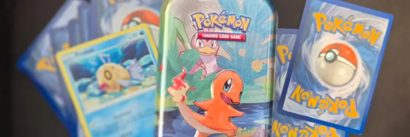 Pokémon-kort og en lille samledåse med Charmander.