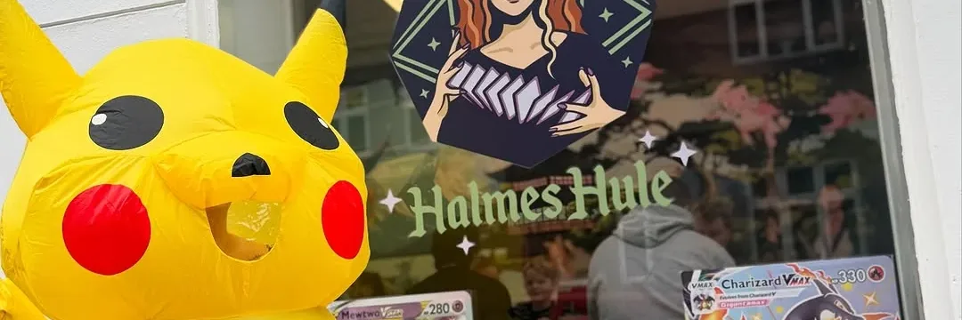 En stor Pikachu-figur foran Halmes Hules butiksvindue med Pokémon-kort og butikkens logo.